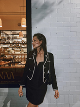 a lady in black cropped knitted jacket with black mini dress